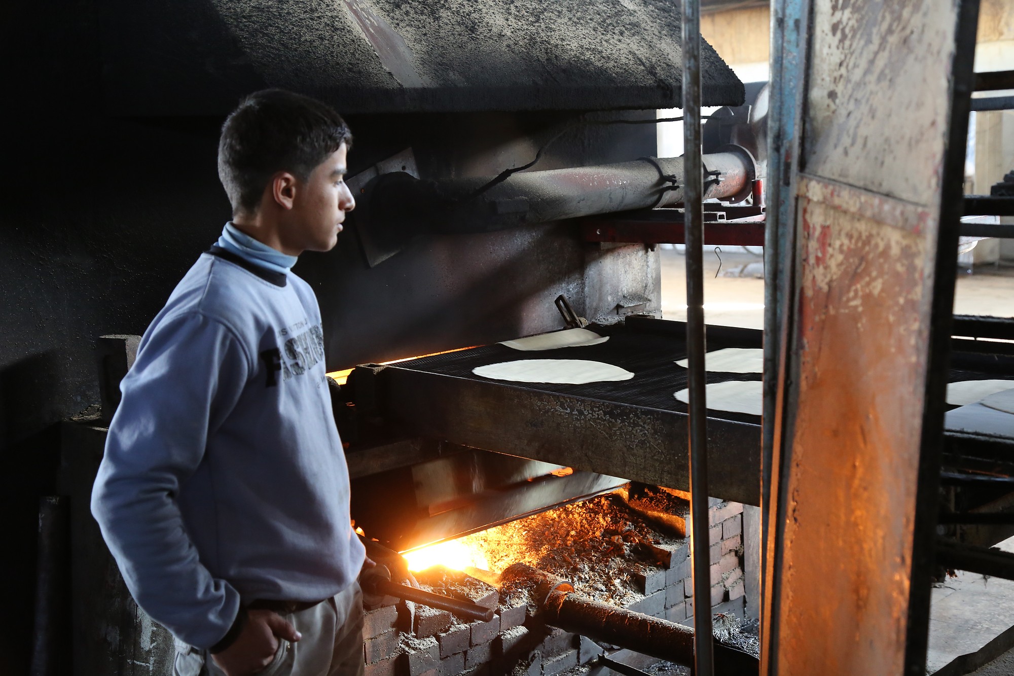 A baker watches the baking of his bread