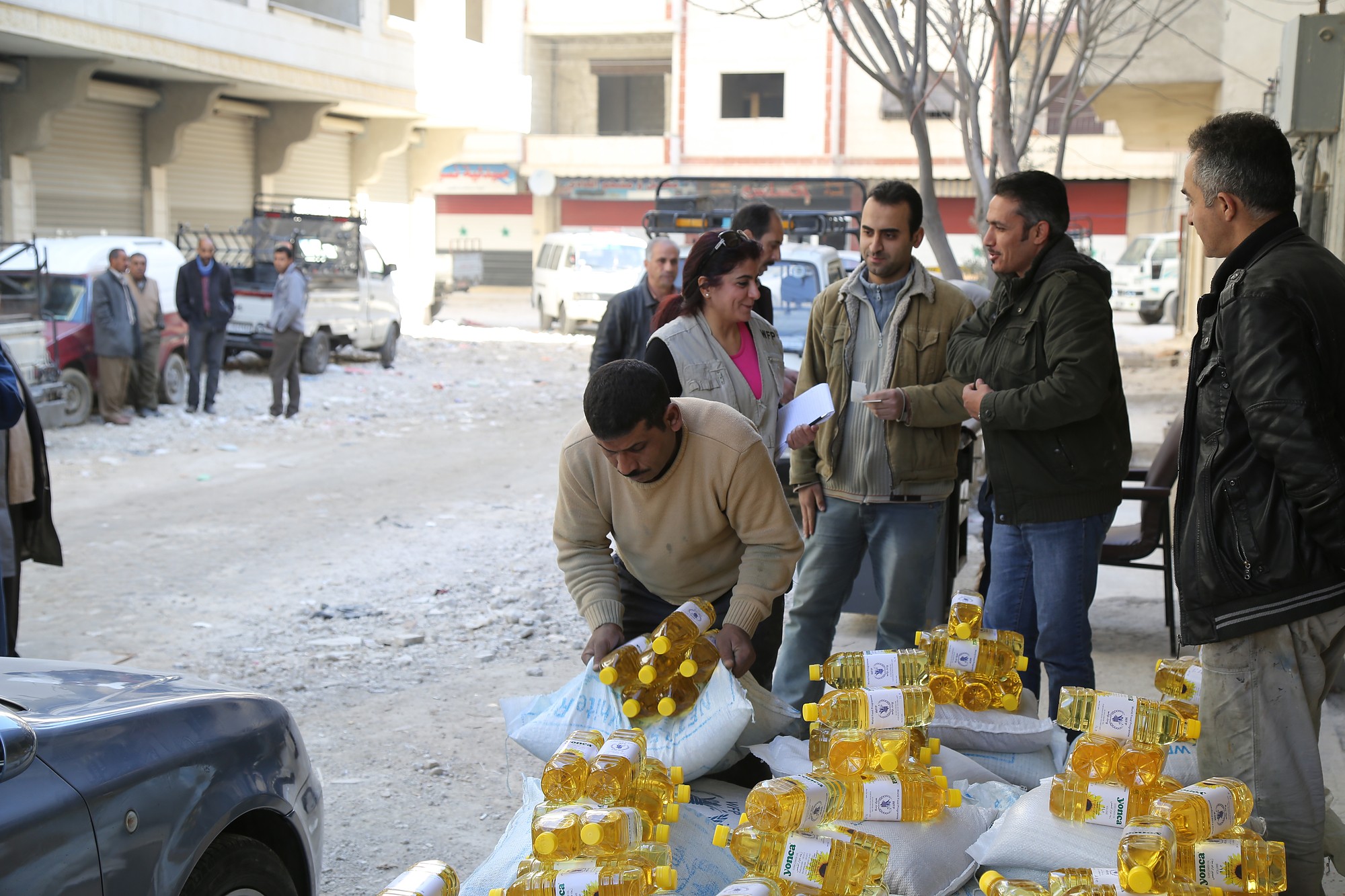 Internally displaced Syrians collect food items from a WFP distribution point in Damascus