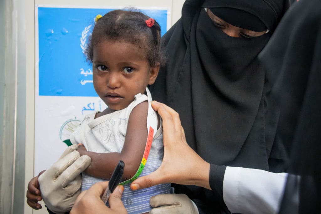 a young girl in yemen has her arm measured