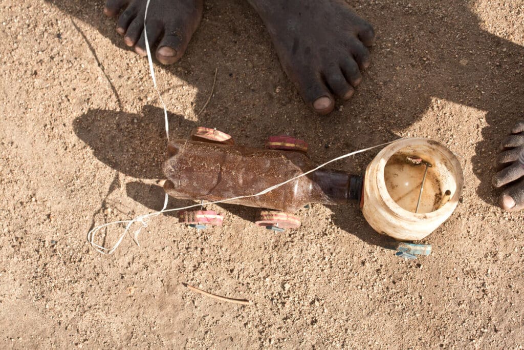 Children's feet are pictured, surrounding a handmade toy.