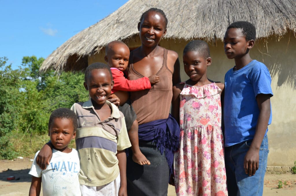 Rebecca stands with all five of her children outside their home in Shamva.