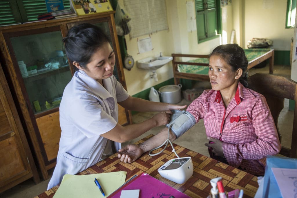 A nurse examines a young mother at a health clinic