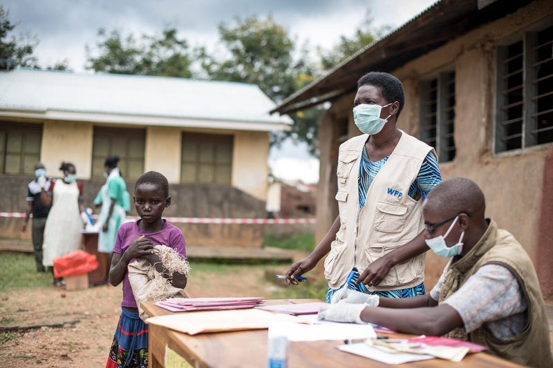 man and woman in WFP vests with young student