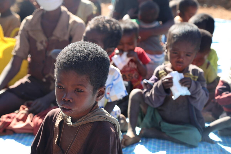 children sitting outside in a large group