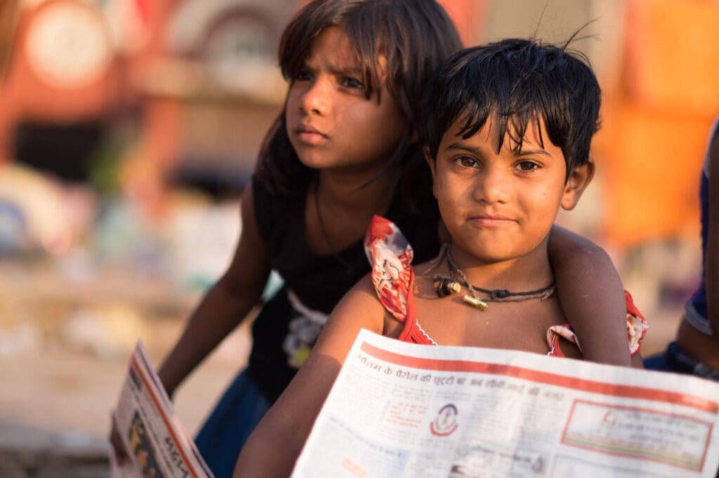 Two young girls sit together, reading.