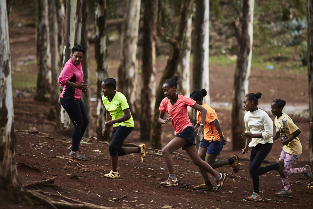 A group of girls from Girls Gotta Run go on a run through a forest