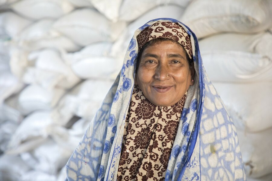 a woman in a head scarf smiles at the camera