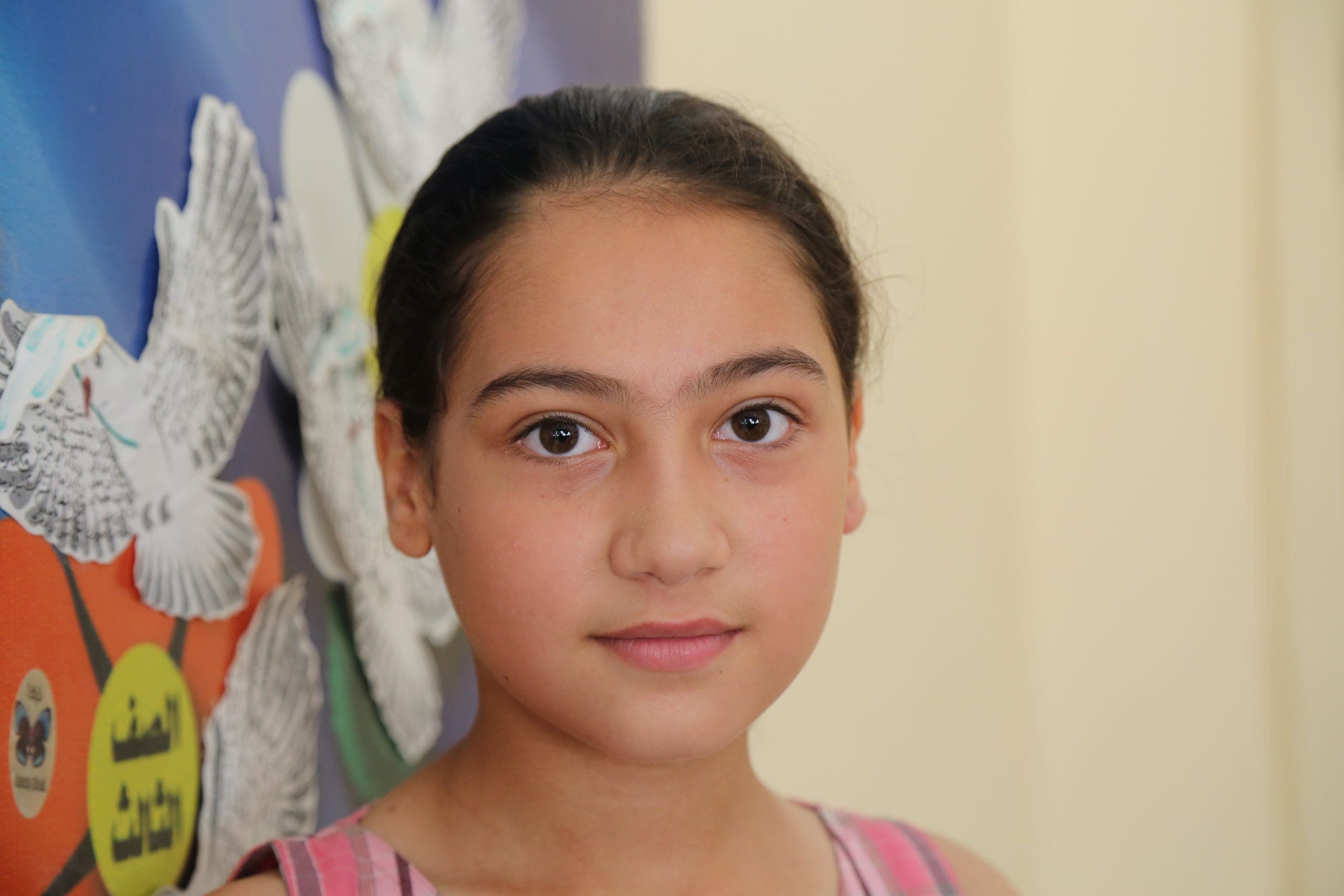 a young schoolgirl in front of class artwork