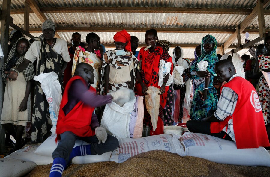 refugees sort through bags of food