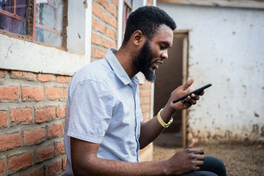 man in blue shirt sitting on the phone