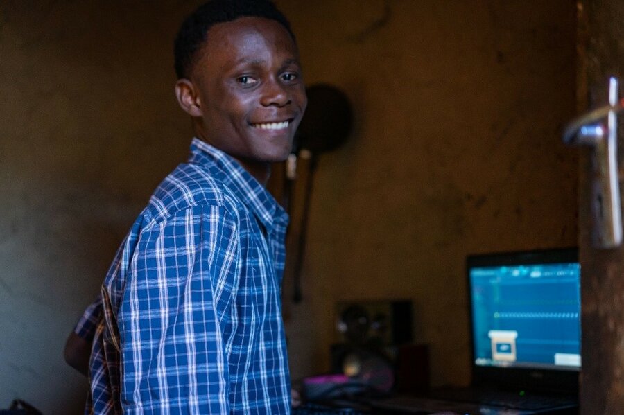 man in blue and white plaid shirt smiling