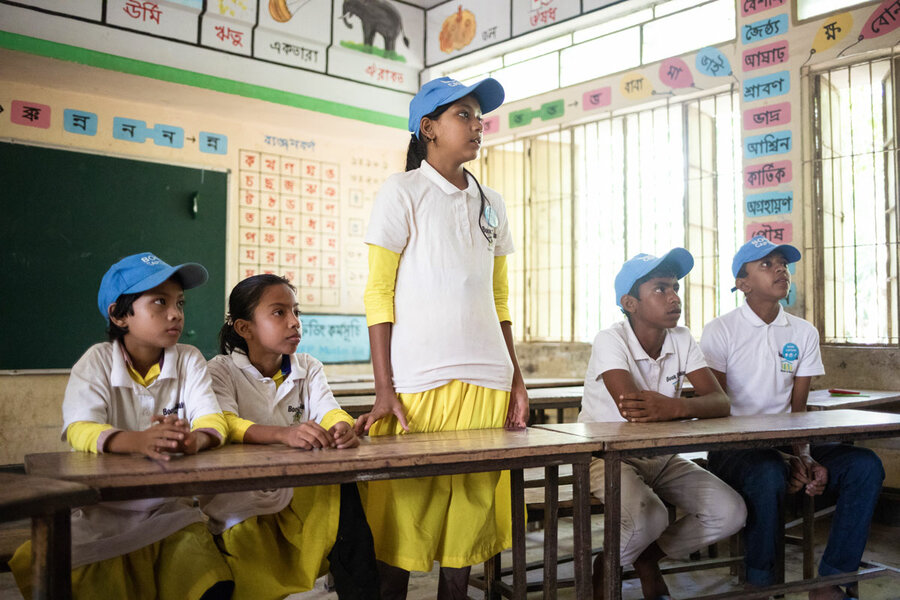 schoolchildren in white and yellow uniforms in class