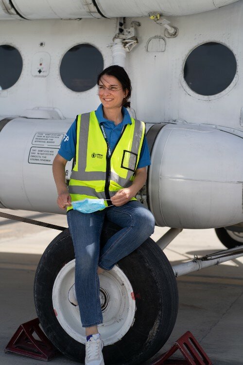 woman leaning on helicopter in yellow vest
