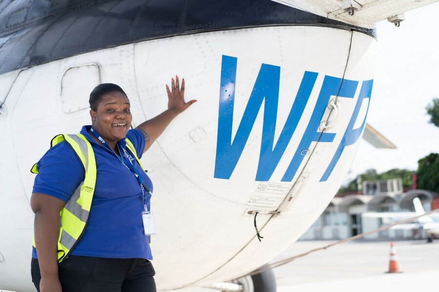 woman leaning on WFP helicopter