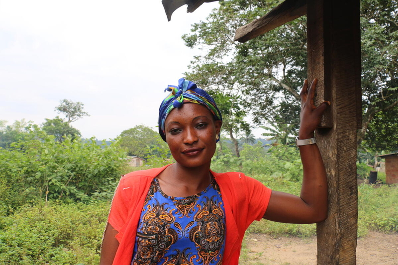 woman in red and blue clothes standing next to tree