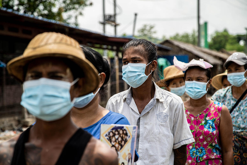 people wait on line while wearing COVID masks