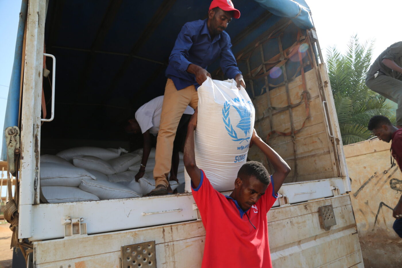 man lifting bag of food onto truck