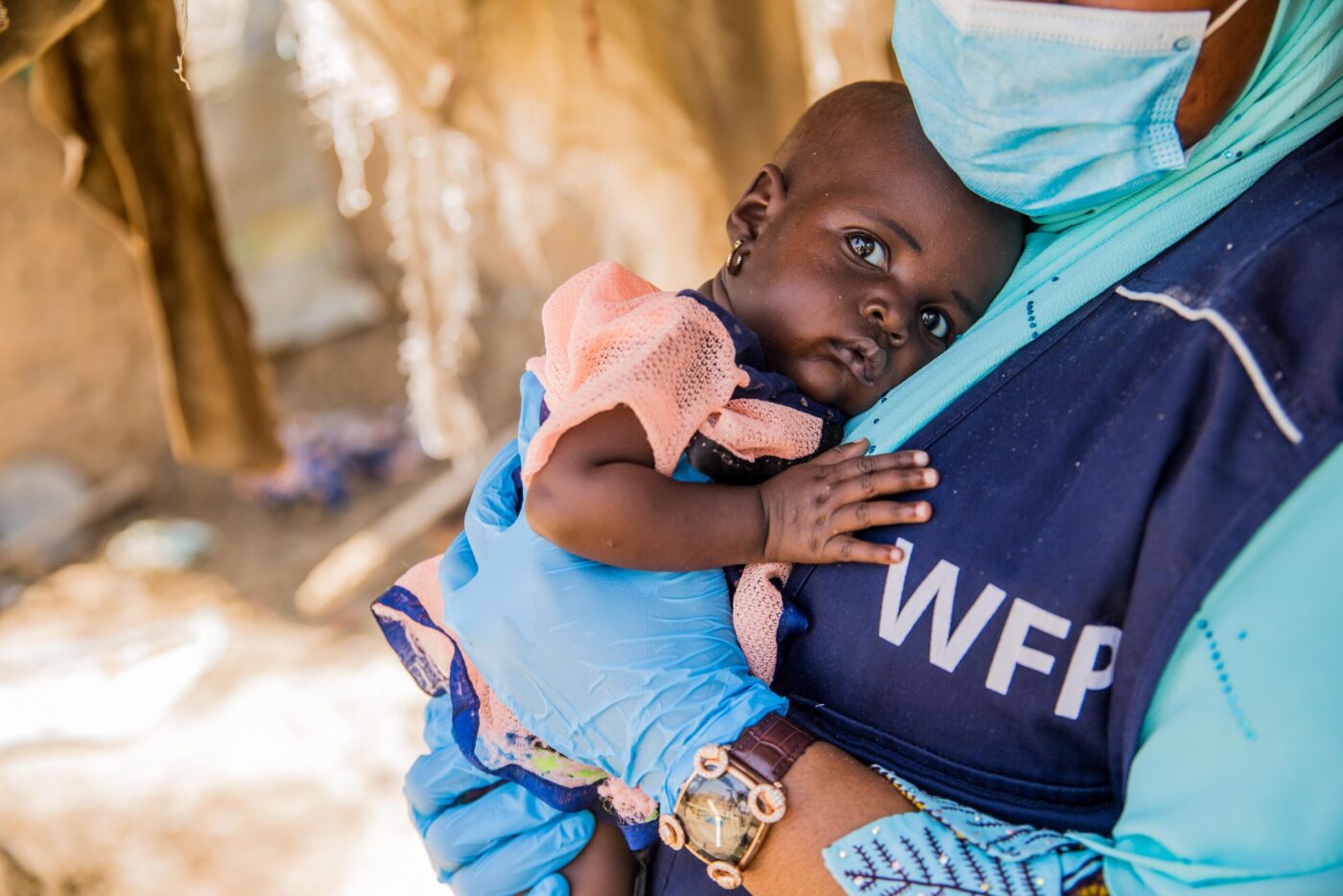 woman in WFP vest holding baby