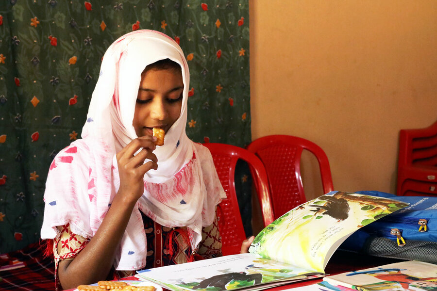 schoolgirl eating biscuit and reading