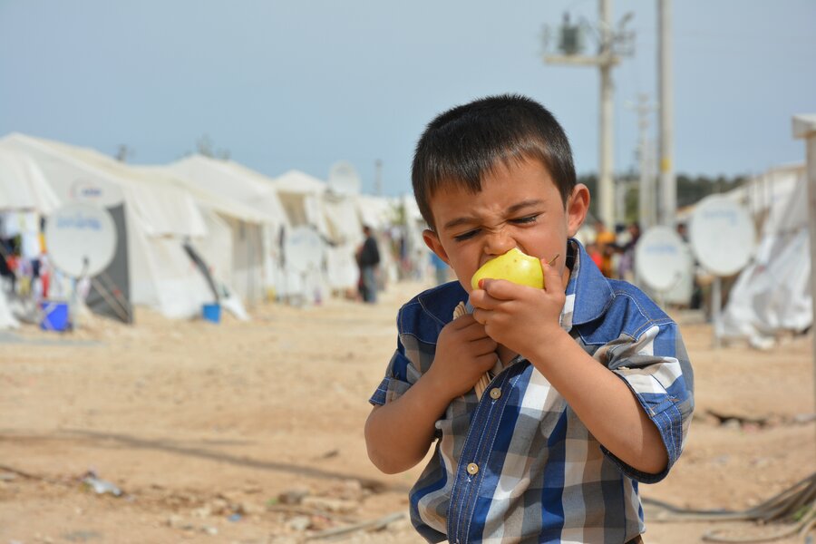 little boy taking bite of a lemon