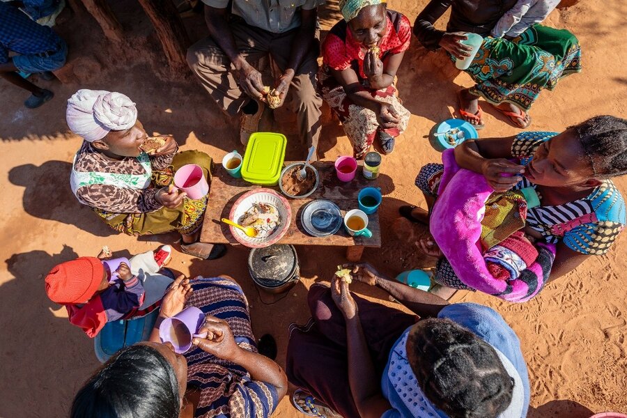 people gather on ground to prepare food
