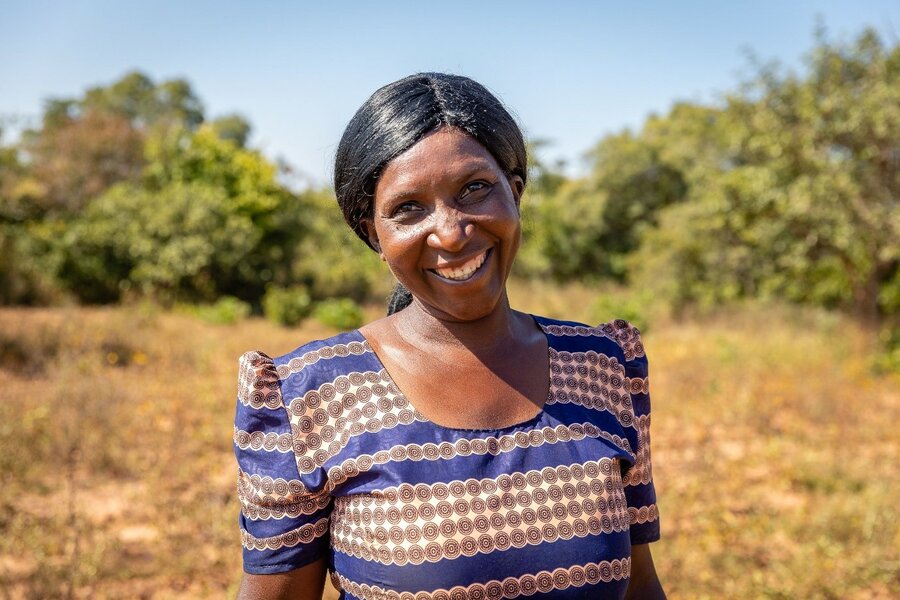 woman in purple shirt smiling in farm field