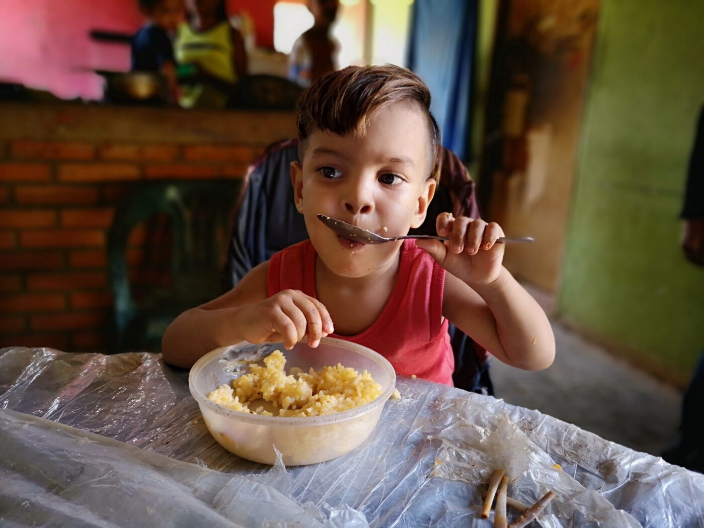 little boy eating food at table