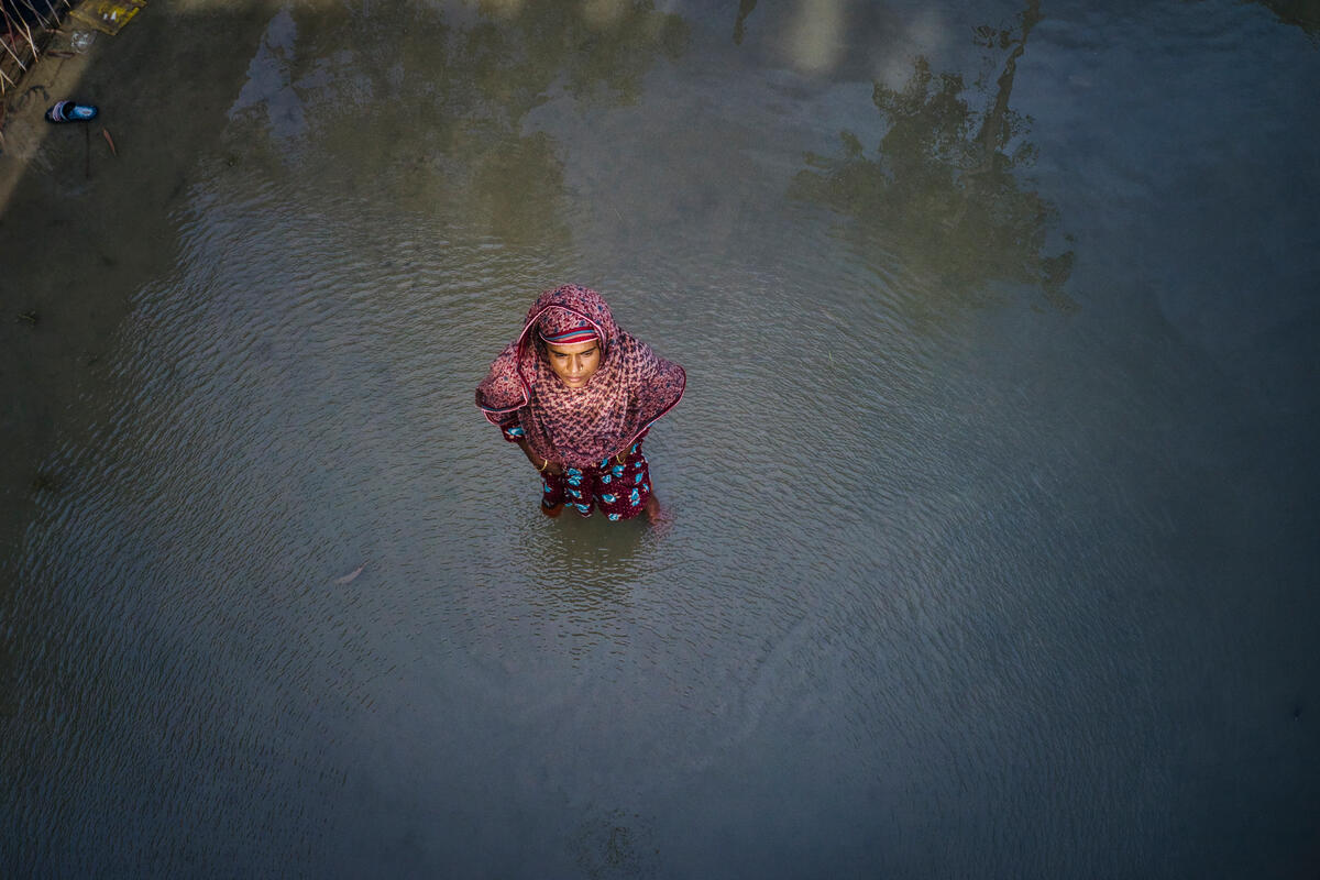 woman in red headscarf standing in great pool of water