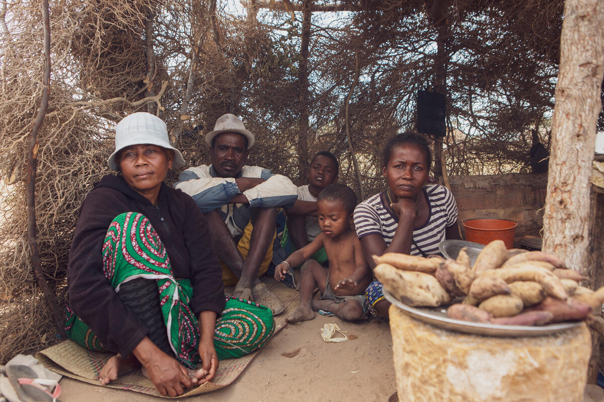 family sitting on floor of hut