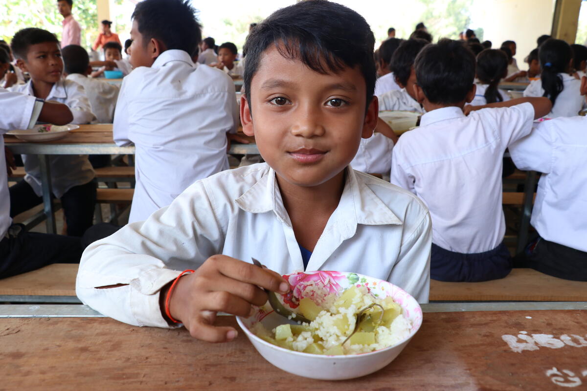 schoolboy in white uniform eating lunch
