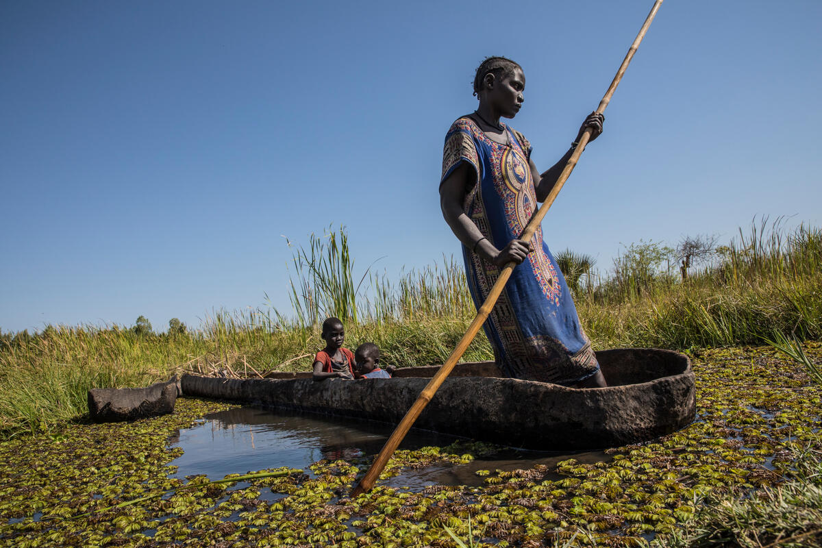 mother rowing boat with two children inside