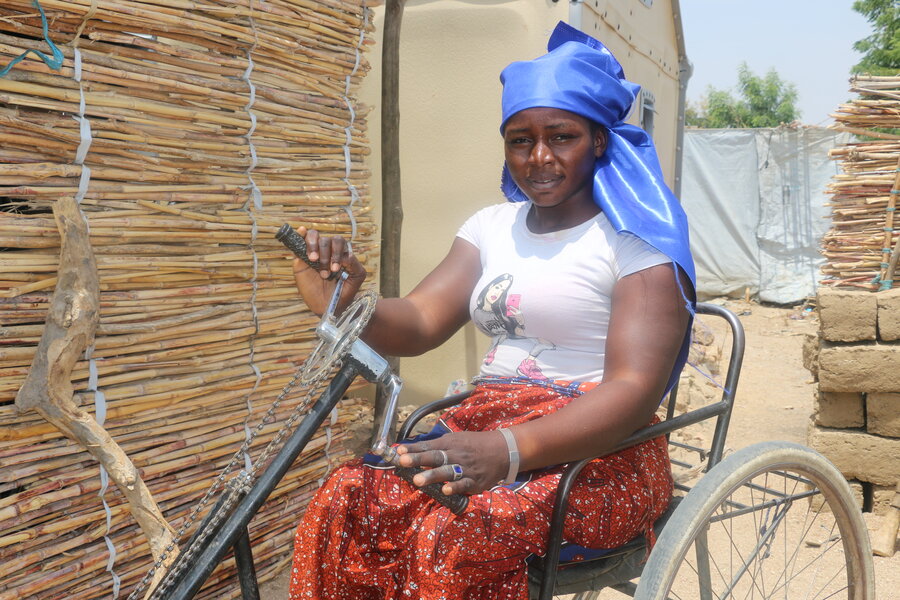 woman in blue headscarf in wheelchair smiling