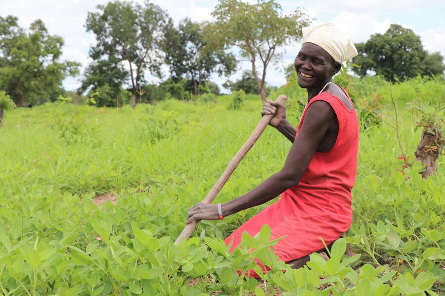 woman in red dress kneeling in field and farming