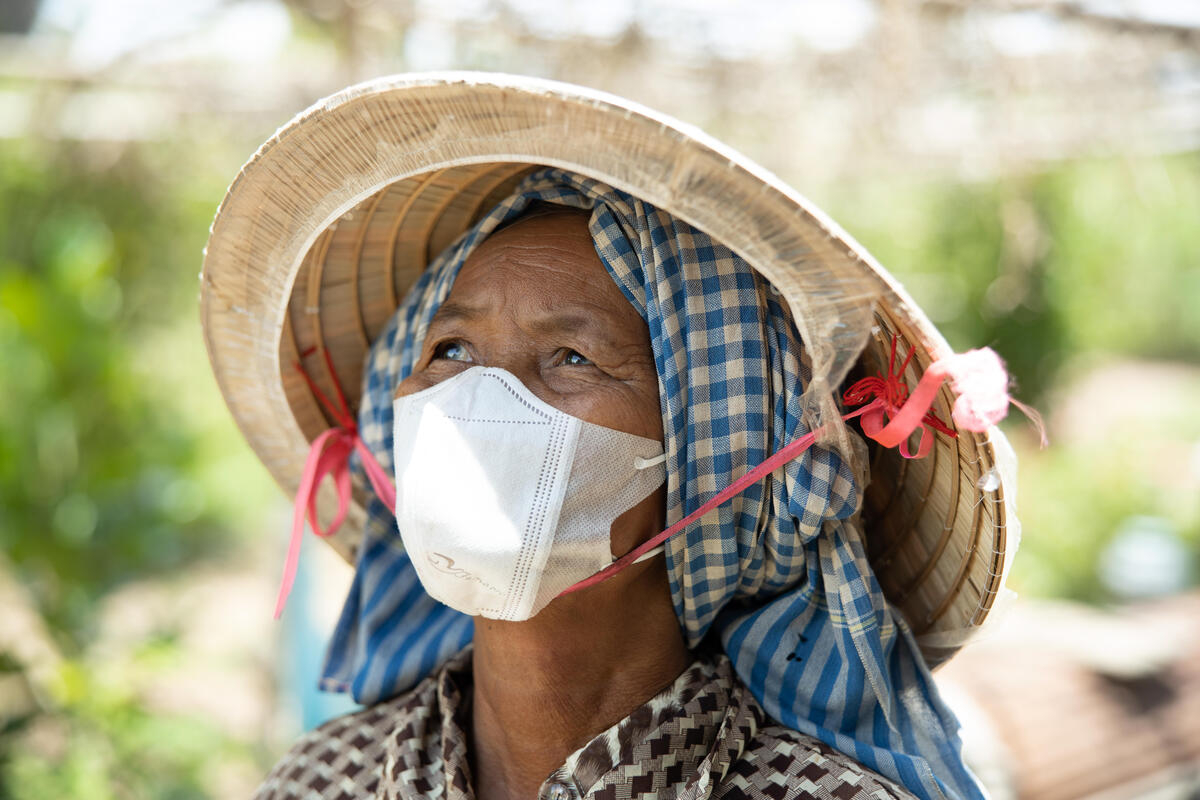 woman in COVID-19 health mask smiling and looking towards the sky