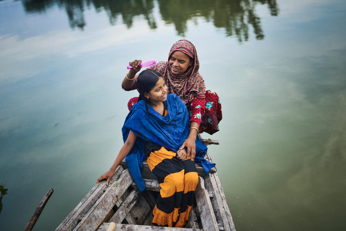 mother and daughter sitting in boat on water