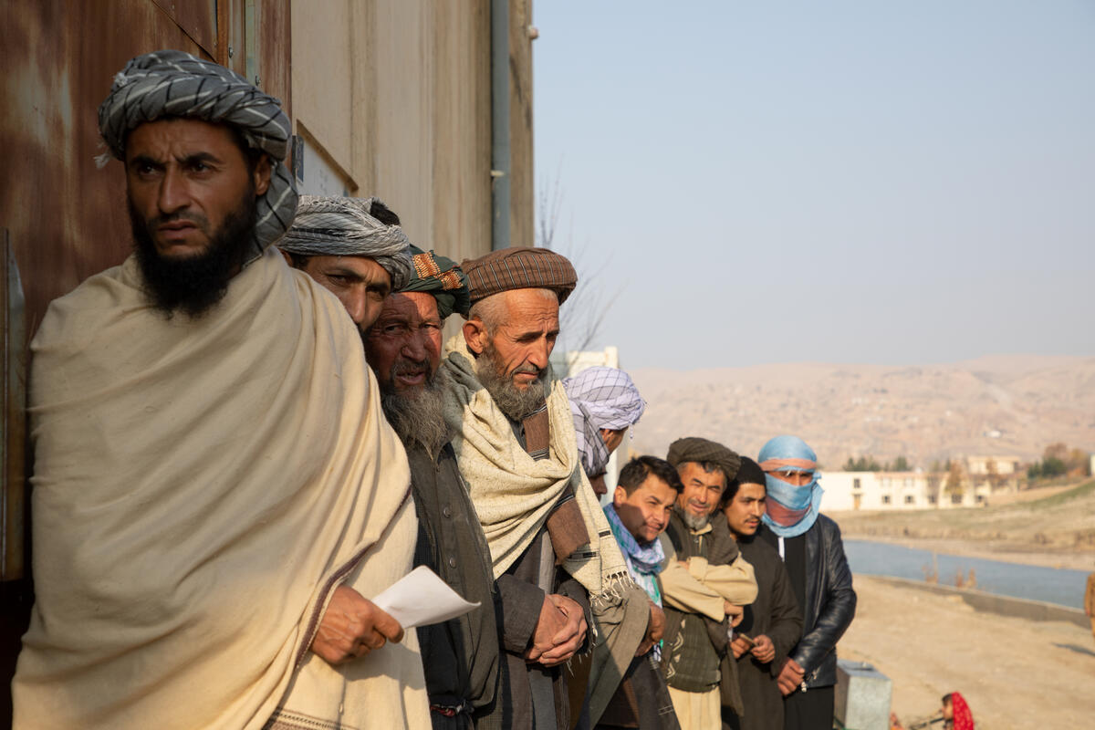 men waiting in line for food distribution