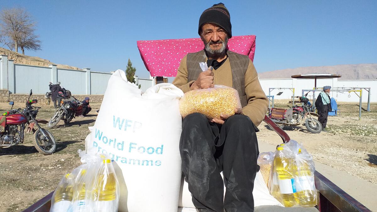 man sitting next to bags of food in truck