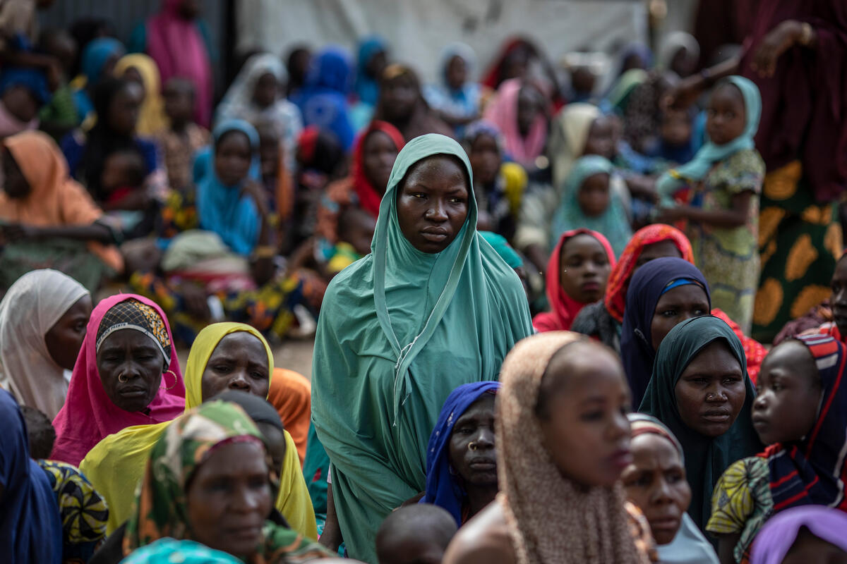 woman in full green headscarf amidst crowd of people