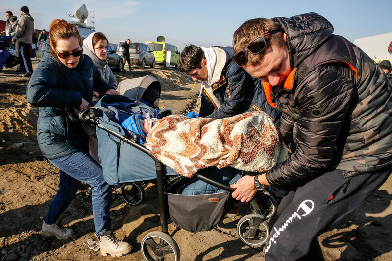 family carrying stroller and belongings