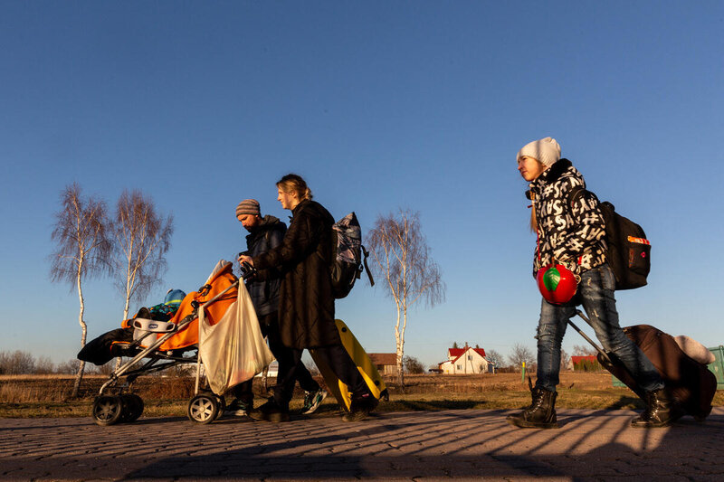 family pushing strolling and carrying suitcases