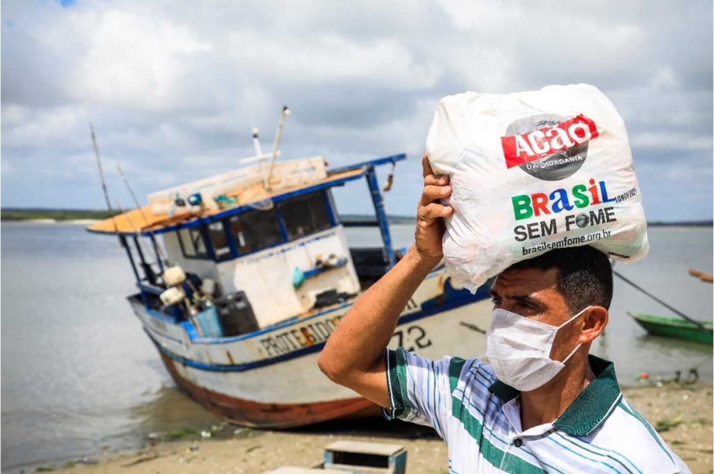 man carrying bag of food by ship