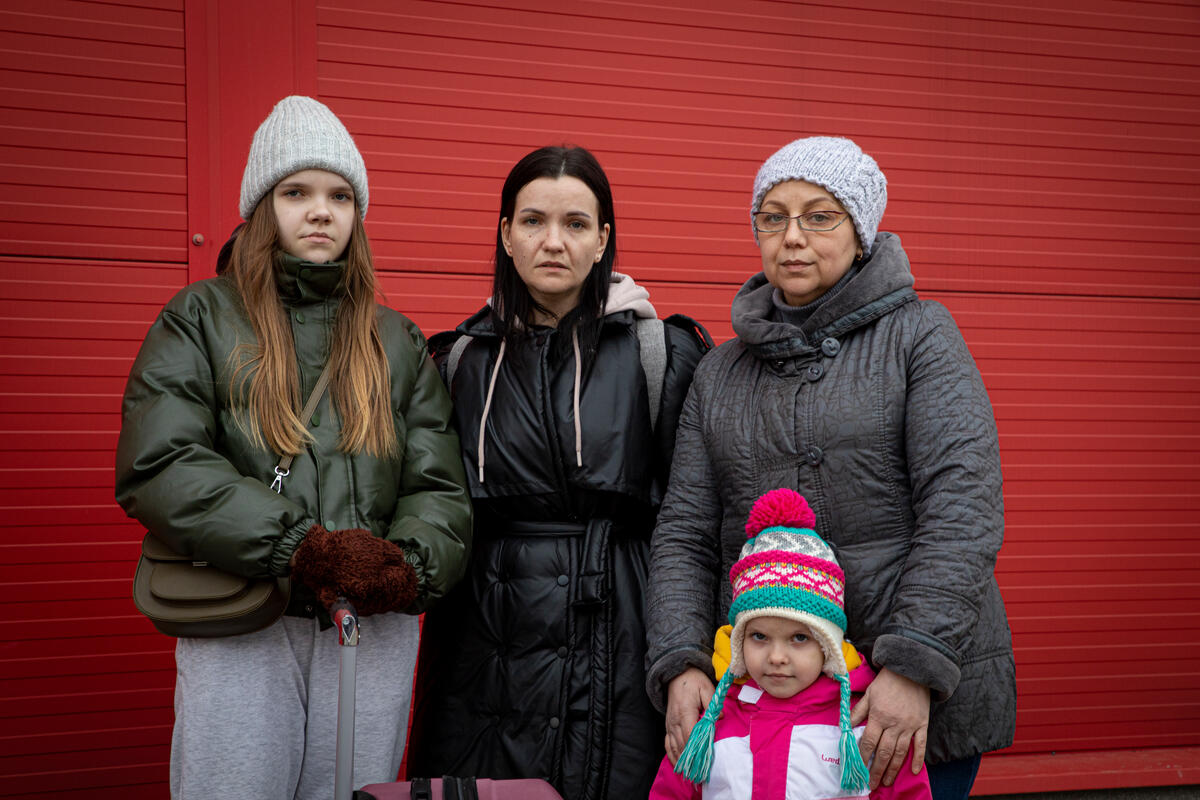 family in winter clothes in front of red building
