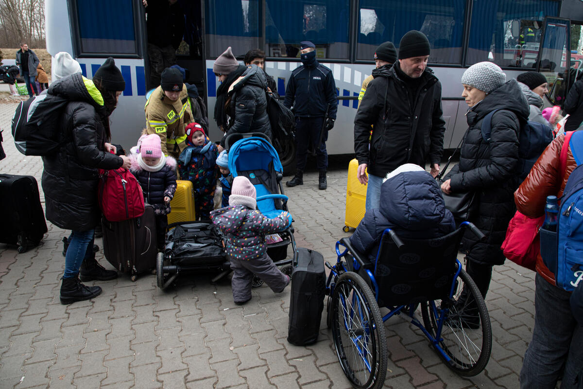 people loading suitcases onto bus