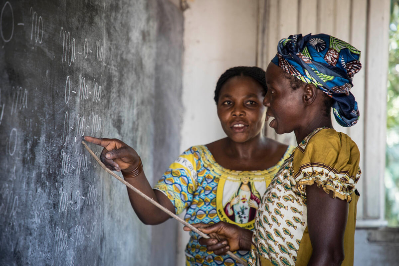 Women teaching and pointing at chalkboard