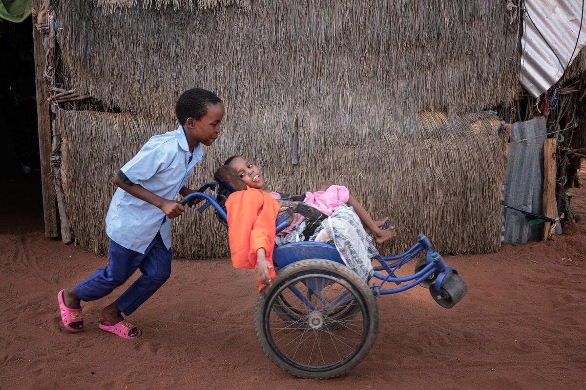 boy pushing girl in wheelchair