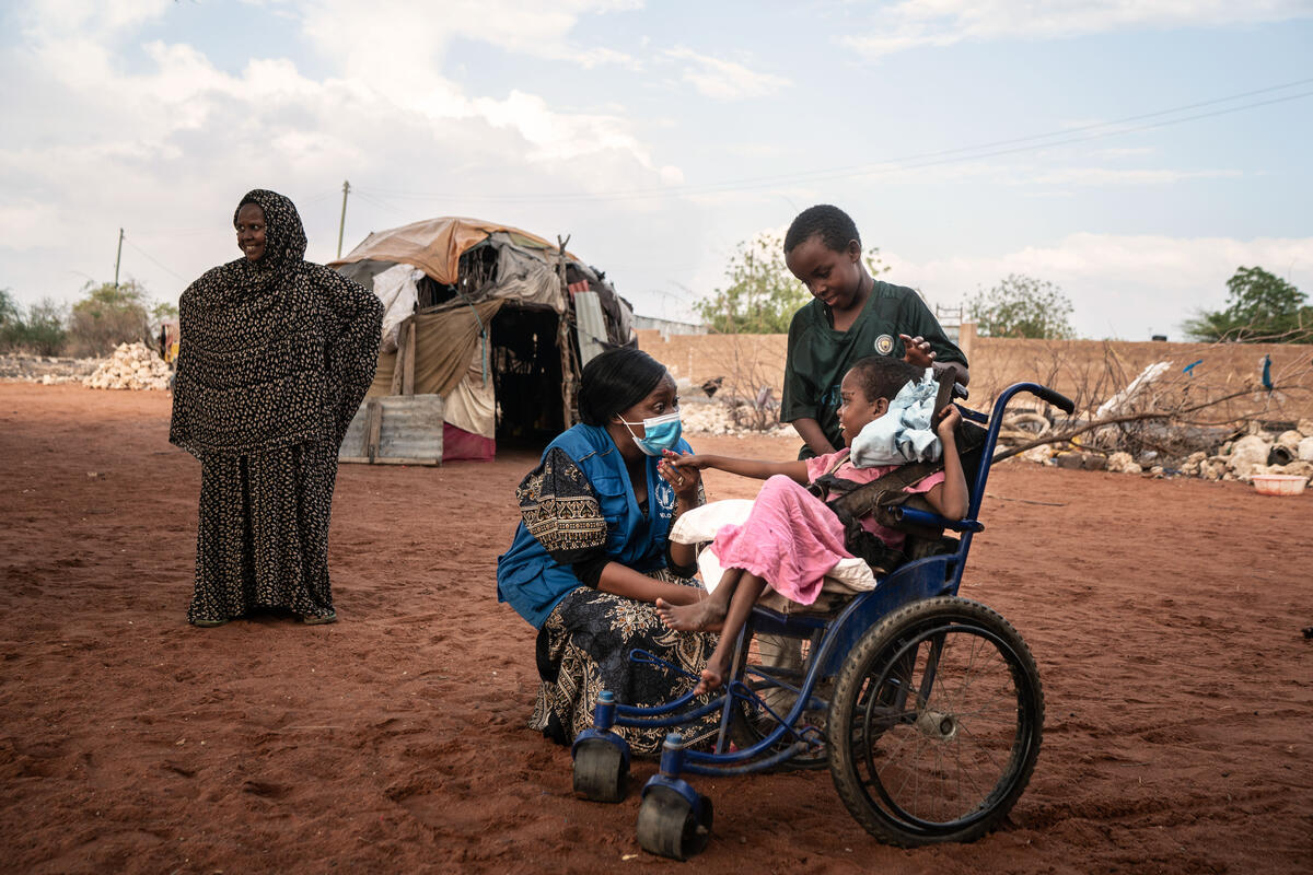 young girl in wheelchair speaking with WFP staff