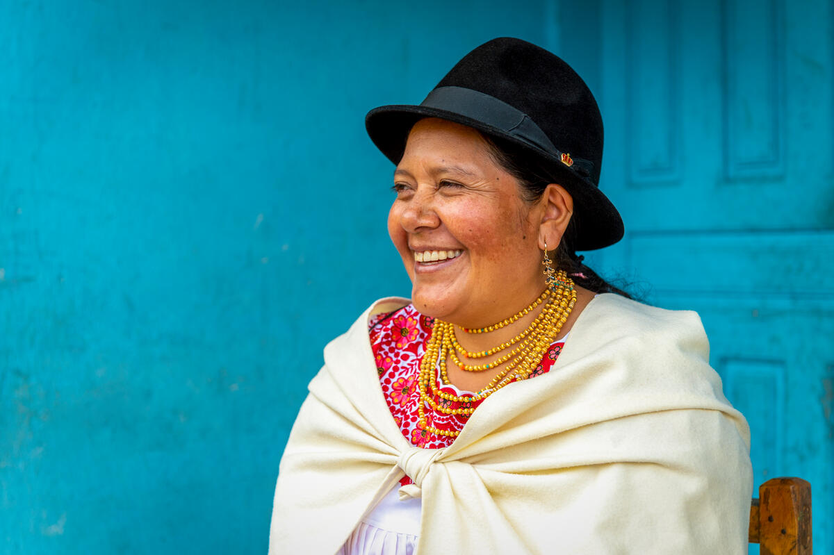 woman in blue hat and white shawl smiling