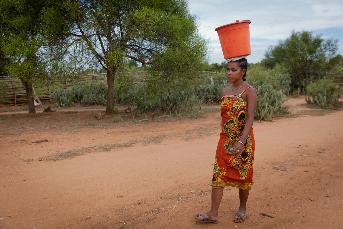 woman carrying bucket of water on her head