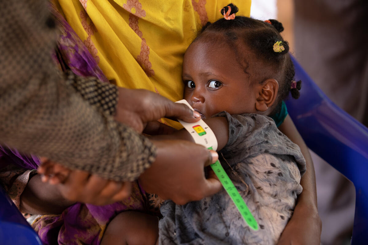 Child has her arm measured for malnutrition