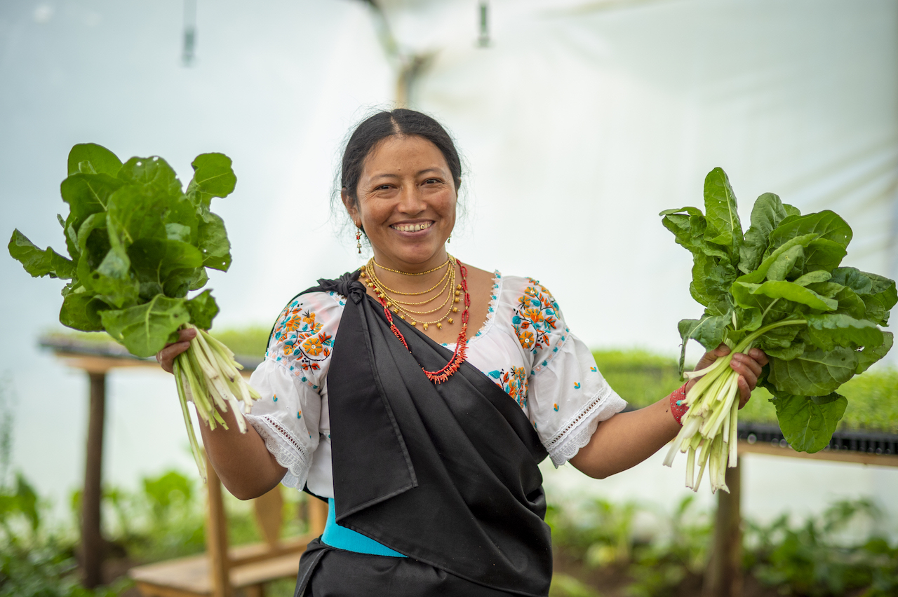 Farmer in Ecuador holds up vegetables